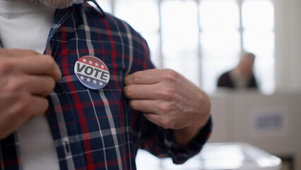 A responsible citizen showing a vote pin on his chest, emphasizing people voting at the polling...