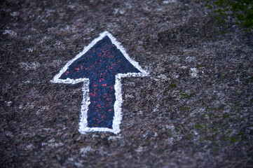 Arrow sign painted on stone. Selective focus.