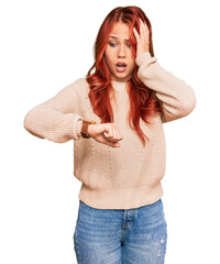 Young redhead woman wearing casual winter sweater looking at the watch time worried, afraid of...