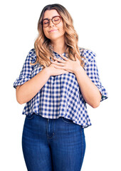 Young caucasian woman wearing casual clothes smiling with hands on chest with closed eyes and grateful gesture on face. health concept.