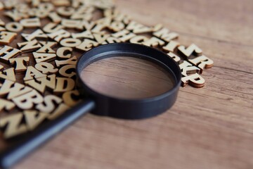 Obraz na płótnie Canvas Magnifying glass with scattered alphabet letters on the table. Copy space for text. Education concept.