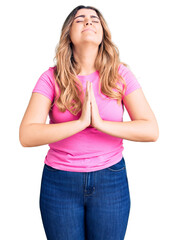 Young caucasian woman wearing sportswear begging and praying with hands together with hope expression on face very emotional and worried. begging.