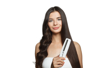 Nice woman using hair iron and straightening her long brown hair on white background, studio...