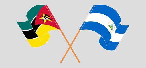 Crossed and waving flags of Mozambique and Nicaragua