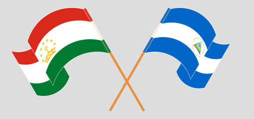 Crossed and waving flags of Tajikistan and Nicaragua
