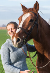 Fototapeta premium Young woman taking care of her horse
