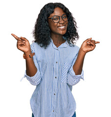 Beautiful african young woman wearing casual clothes and glasses smiling confident pointing with fingers to different directions. copy space for advertisement