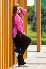 Obraz premium Fashionable girl near a wooden wall at home
