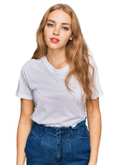 Fototapeta premium Young caucasian girl wearing casual white t shirt with serious expression on face. simple and natural looking at the camera.