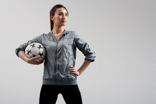 Determined Woman Carrying a Soccer Ball - Powered by Adobe