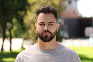 Portrait of handsome young man outdoors on sunny day