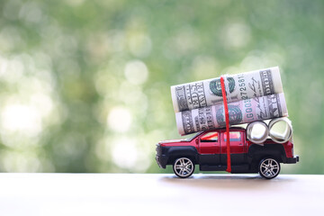 Miniature car and usd dollar money on nature green background, Saving money for car, Finance and car loan, Investment and business concept