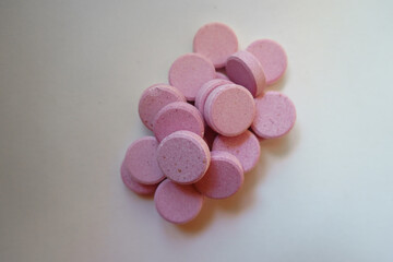 Fistful of big pink oral probiotic tablets from above