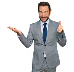 Middle age man wearing business clothes showing palm hand and doing ok gesture with thumbs up, smiling happy and cheerful