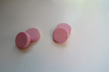 Close shot of four big pink oral probiotic tablets