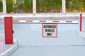 Sign with text Authorized Vehicles Only on boom barrier outdoors