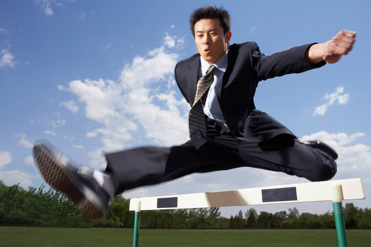 Businessman Jumping Over A Hurdle