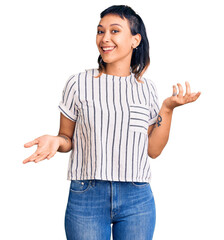 Young woman wearing casual clothes smiling cheerful with open arms as friendly welcome, positive and confident greetings - obrazy, fototapety, plakaty