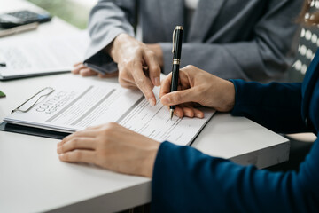 Real estate broker agent presenting and consult to customer to decision making sign insurance form agreement, home model, concerning mortgage loan offer in office.