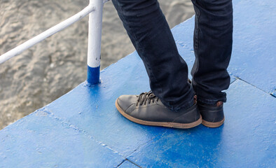 Close-up of shoes on a man's feet on a blue floor