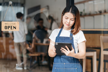 Startup successful small business owner sme beauty girl stand with tablet in her coffee shop. Portrait of asian woman barista cafe owner. SME entrepreneur business concept.