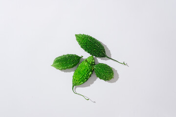 On a white background, bitter melon also known as bitter gourd isolated. Top view, minimal scene of...