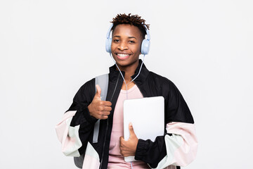 Portrait of a cheerful young afro american dark skinned man dressed in sweatshirt carrying backpack...