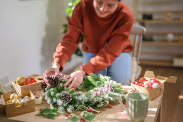 Woman making mistletoe wreath Christmas wreath decoration with hand made DIY winter greenery florist hands making Christmas wreath beautiful mistletoe.