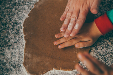  a mom and her son engage in the delightful task of preparing Christmas gingerbread