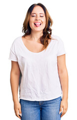 Fototapeta premium Young beautiful caucasian woman wearing casual white tshirt sticking tongue out happy with funny expression. emotion concept.