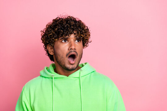 Photo of young poor student indian guy wear green trendy hoodie amazed steam autumn sale look empty space isolated on pink color background