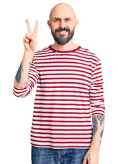 Young handsome man wearing casual clothes showing and pointing up with fingers number two while smiling confident and happy.