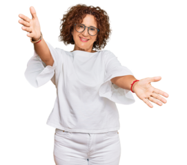 Beautiful middle age mature woman wearing casual clothes and glasses looking at the camera smiling with open arms for hug. cheerful expression embracing happiness.