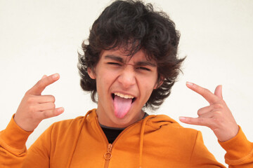 latin hispanic teenager isolated on white with rebellious gesture sticking out his tongue