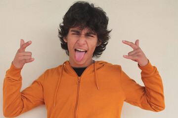 teenager isolated on white with rebellious gesture sticking out his tongue