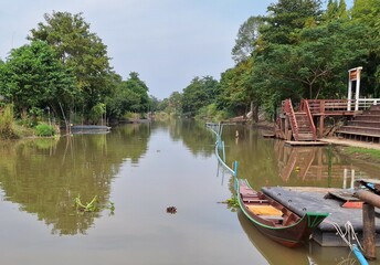 Fototapeta na wymiar Blurred rural canal scenery with boats
