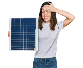 Young beautiful girl holding photovoltaic solar panel stressed and frustrated with hand on head, surprised and angry face