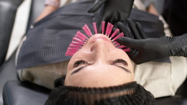 Thread lifting is a cosmetic facial rejuvenation procedure. A cosmetologist implants cosmetic threads under the skin for face lifting and rejuvenation in a modern clinic.