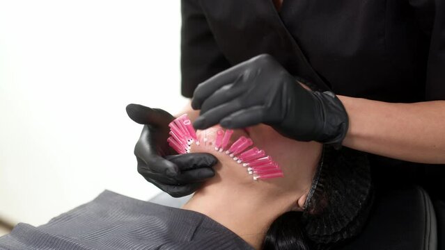 Thread lifting is a cosmetic facial rejuvenation procedure. A cosmetologist implants cosmetic threads under the skin for face lifting and rejuvenation in a modern clinic.