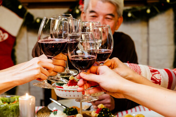 Happy and Cheerful group of extended Asian family has a toast and cheer during Christmas dinner at home. Celebration holiday togetherness. Family gatherings and reunion happy new year holiday season.