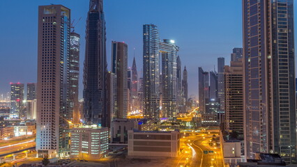 Many towers and skyscrapers with traffic on streets in Dubai Downtown and financial district night...