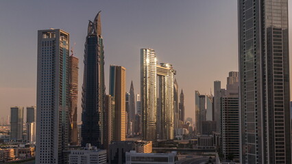 Many towers and skyscrapers with traffic on streets in Dubai Downtown and financial district morning timelapse.