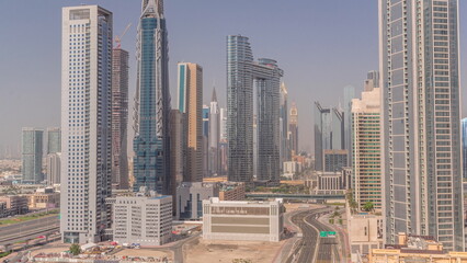 Many towers and skyscrapers with traffic on streets in Dubai Downtown and financial district all day timelapse.