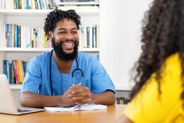 Funny african american male nurse talking with female patient