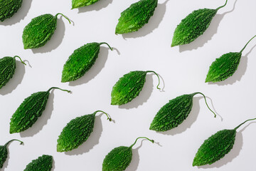 Fresh green bitter melons arranged on a white background. Creative scene for advertising and...