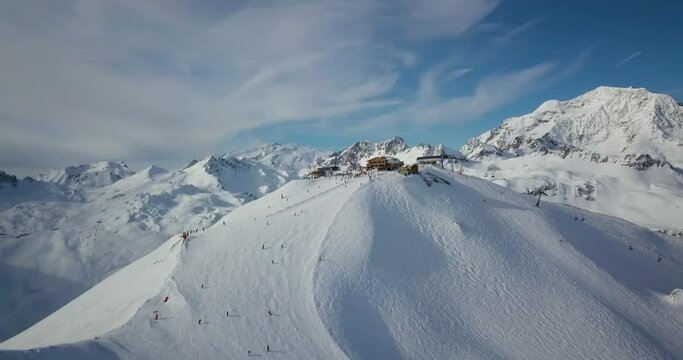 drone footage of france alps ski resort with snow mountains and people skiing 