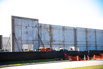 Precast concrete wall panels, prefabricated mega warehouse building material construction site with steel scaffolding framework under isolated white background sky, walling system, Dallas, TX