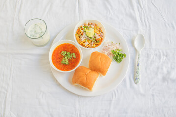 Misal Pav with buttermilk is a special dish in Maharashtra, India. for breakfast or as a midday snack, served over a white background - obrazy, fototapety, plakaty