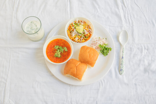 Misal Pav with buttermilk is a special dish in Maharashtra, India. for breakfast or as a midday snack, served over a white background
