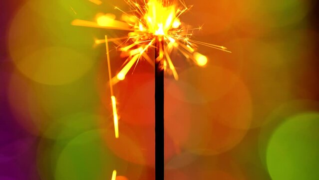 Lightening sparkler on the colorful background. Bengal light burning on a colorful background. Holiday party concept. New Year party sparkler